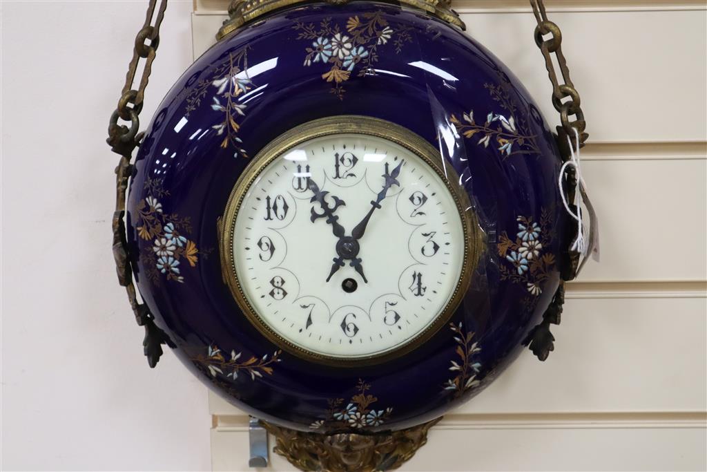 A late 19th century French wall clock, with floral-decorated blue ceramic frame, circular enamelled dial and gilt metal mounts